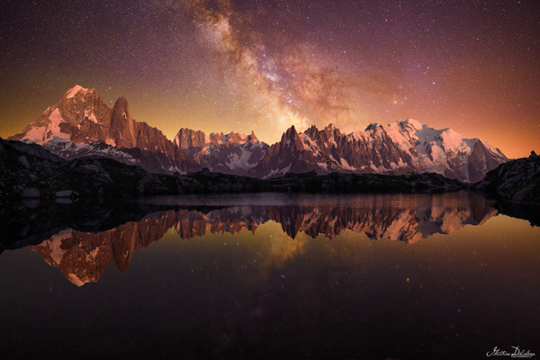 Alpine peaks reflecting on the Lac des Chéserys with a Golden Milky Way